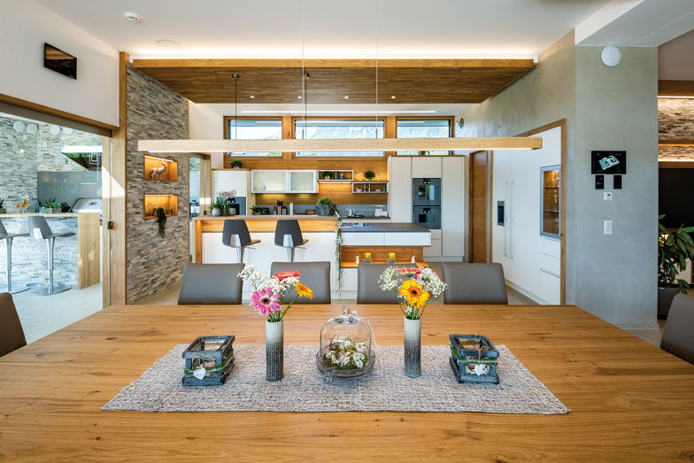 Die Küche mit Essbereich ist beeindruckend. Die vielen Naturmaterialien und die geschickte Raumplanung sorgen für eine behagliche Atmosphäre. 