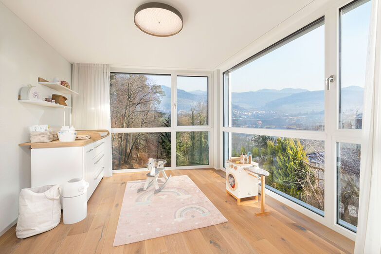 Das Eckfenster bietet einen atemberaubenden Blick in ­die Umgebung und in die Baumkronen des nahen Waldes.