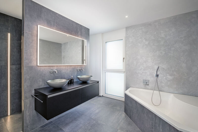 Stylisches Bad mit modernen Badmöbeln und Lichtband in der Dusche.