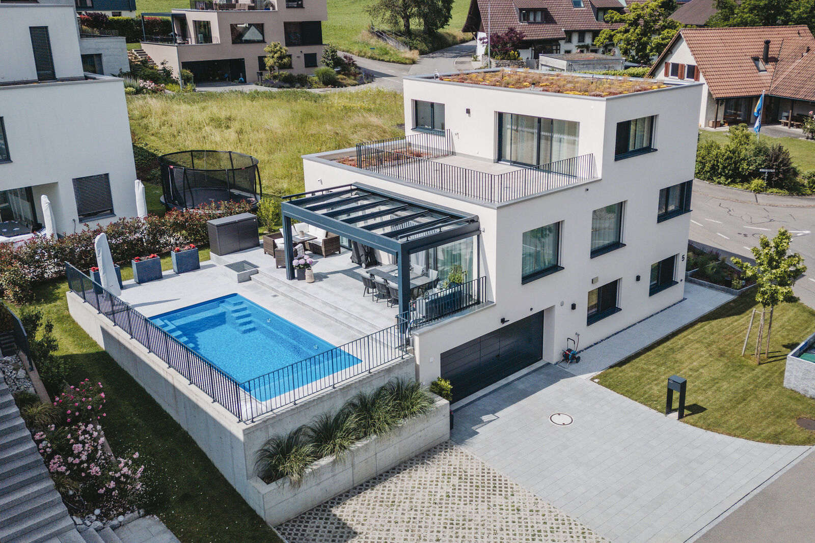 Klare Linien und viele Fenster machen das Einfamilienhaus mit Pool attraktiv.