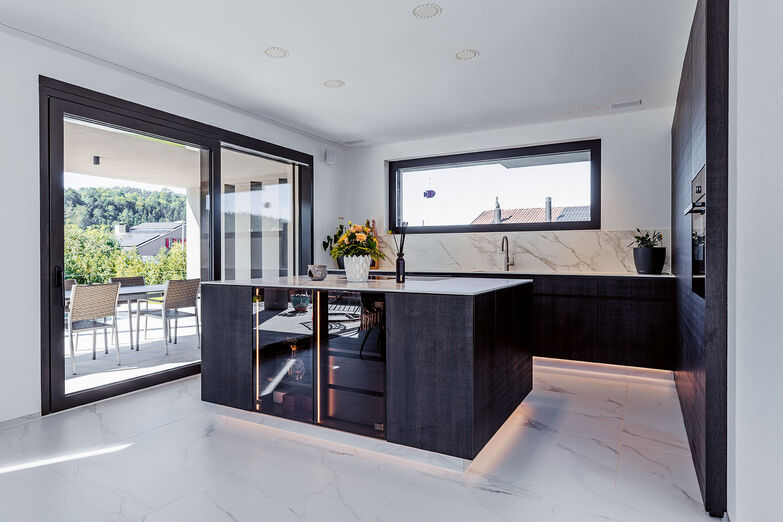 Die moderne Küche mit ­verstecktem Zugang zum Reduit passt perfekt zum modernen Stil des Hauses. © Matthias Eberle Fotografie