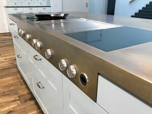 Wenn es um Metall in verschiedenen Formen und Grössen geht, so sind der Fantasie und Kreativität (fast) keine Grenzen gesetzt. Diese Arbeitsplatte aus Messing ist mit einem Wirbelfinish patiniert, und eine angeschweisste Blende mit Bedienknebel setzt elegante Akzente. Merial AG.