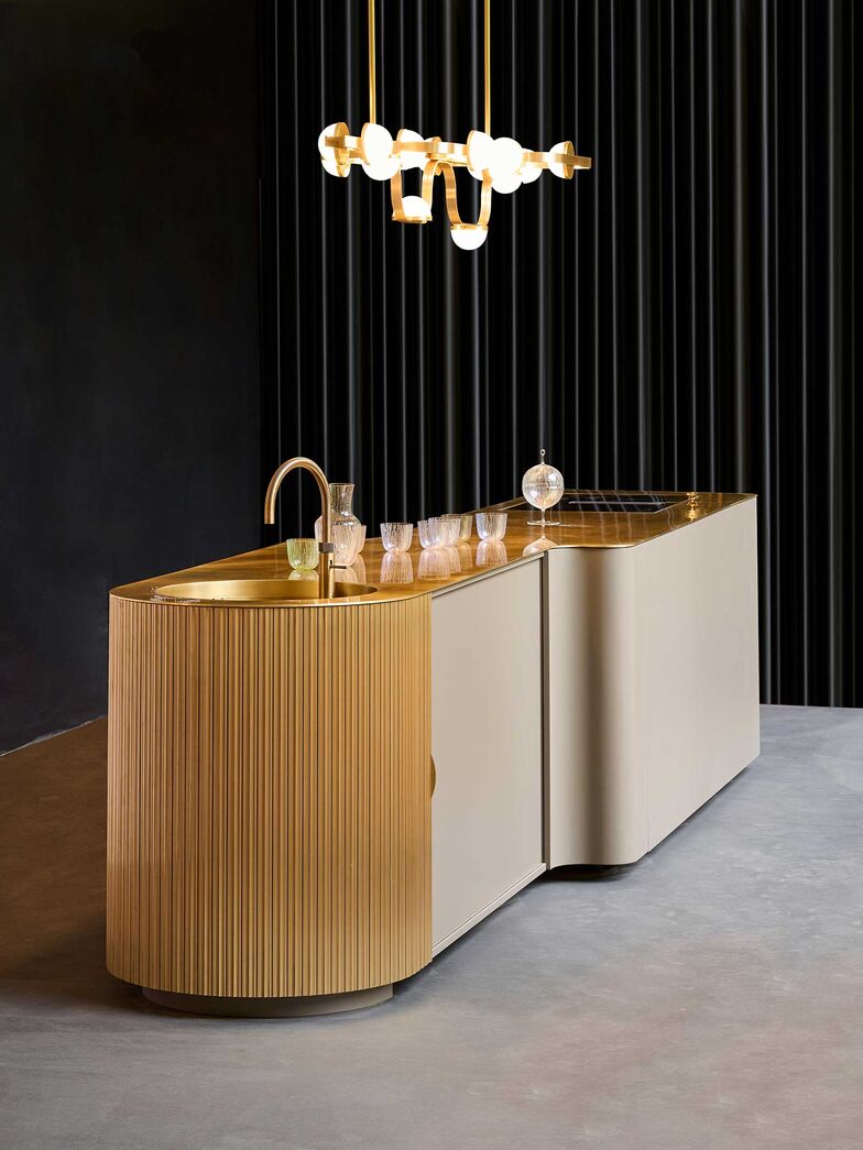 Die nach ihrer markanten, geschwungenen Form benannte «S-Linie» verbindet warmes Holz mit edlem Messing zu einer harmonischen Einheit. Designer Bodo Sperlein beweist damit sein Gespür für Räume, die gleichermassen Eleganz und Funktionalität verkörpern.