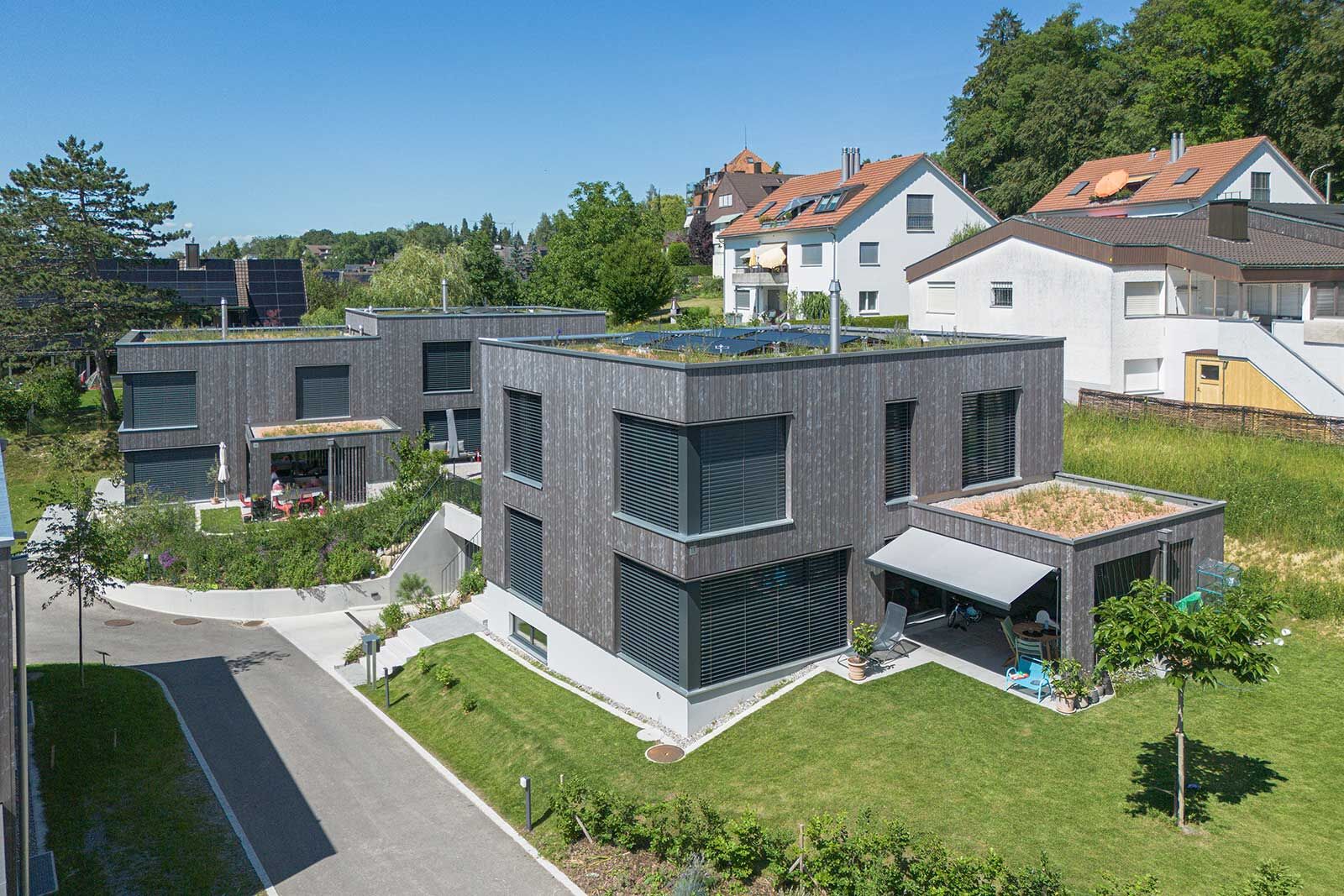 Ruhige Holzfassaden und begrünte Flachdächer: Die neue Siedlung setzt auf zeitgemässe Architektur und individuelle Wohnräume.