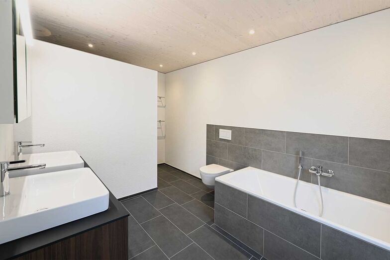 Hinter der Trennwand ist die geräumige Dusche.