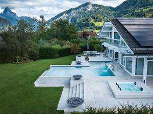 Ein elegantes Gartenbad mit Infinity-Überlaufrinne und integriertem Riviera-Whirlpool Strato 2.3 (5 Sitzplätze) schafft ein luxuriöses Wellness-Erlebnis. Die moderne Überlaufrinne lässt den Wasserspiegel auf Augenhöhe des Schwimmers erscheinen und verschmilzt optisch mit dem Horizont. Ergänzt wird die Anlage durch eine Schwalldusche und eine hochwertige, solarbetriebene Lamellenabdeckung mit zwei Rollläden für optimalen Schutz und Energieeffizienz. Marlin.
