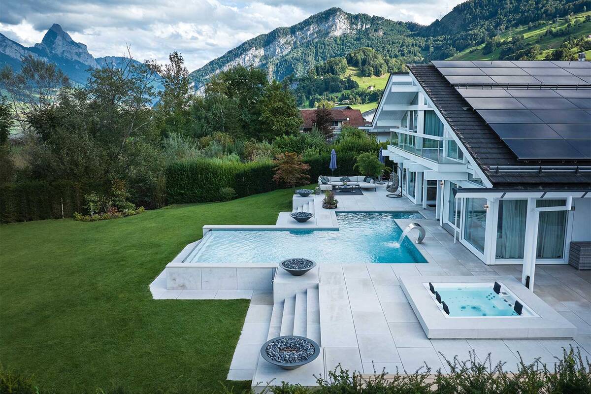 Ein elegantes Gartenbad mit Infinity-Überlaufrinne und integriertem Riviera-Whirlpool Strato 2.3 (5 Sitzplätze) schafft ein luxuriöses Wellness-Erlebnis. Die moderne Überlaufrinne lässt den Wasserspiegel auf Augenhöhe des Schwimmers erscheinen und verschmilzt optisch mit dem Horizont. Ergänzt wird die Anlage durch eine Schwalldusche und eine hochwertige, solarbetriebene Lamellenabdeckung mit zwei Rollläden für optimalen Schutz und Energieeffizienz. Marlin.