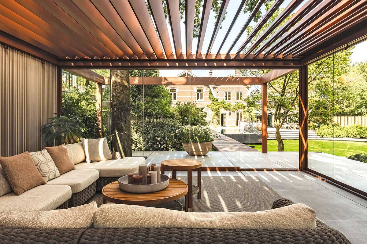 Die weichen Konturen in ruhigen Erdtönen und die natürlichen Materialien der Terrassenüberdachung wirken elegant und edel. Die klaren Linien strahlen Ruhe aus. Glasschiebetüren, Beleuchtungsarmaturen und faltbare Loggia-Paneele vervollständigen das Bild. Renson.