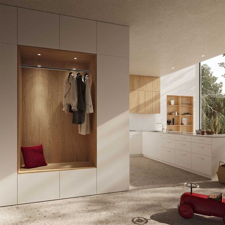 Die Möbel verschmelzen mit dem Raum. Die Garderobe ist mit der Küche verbunden und ein Hochschrank fungiert als Tür ins Reduit. Dabei sorgen Akzente in Holz für eine natürliche Atmosphäre. Veriset AG, www.veriset.ch